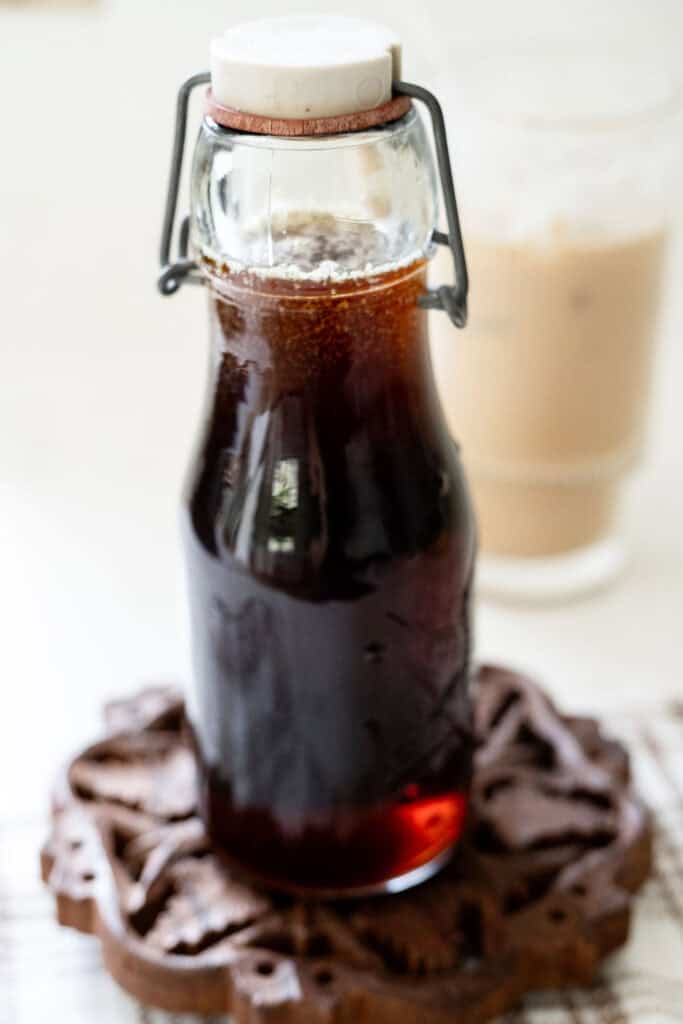 bottle of syrup in front of iced coffee