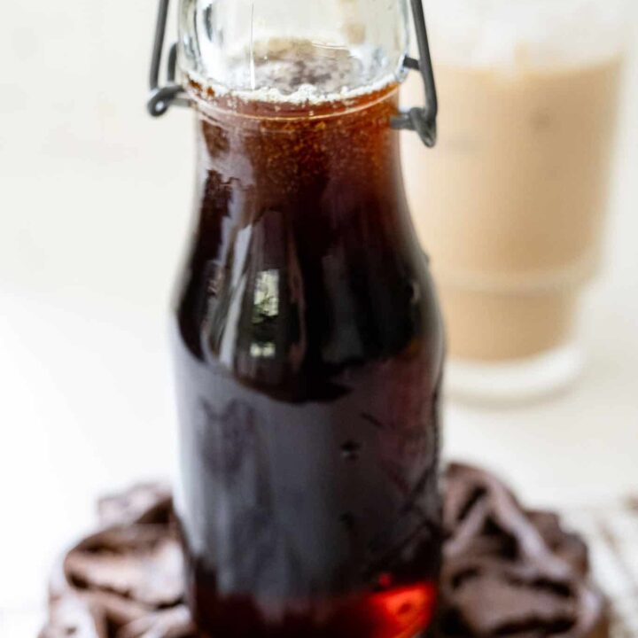 bottle of syrup in front of iced coffee