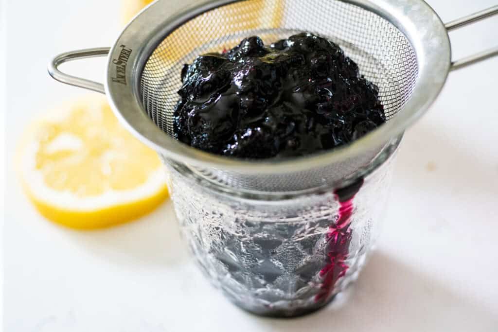 straining blueberry sauce after cooked