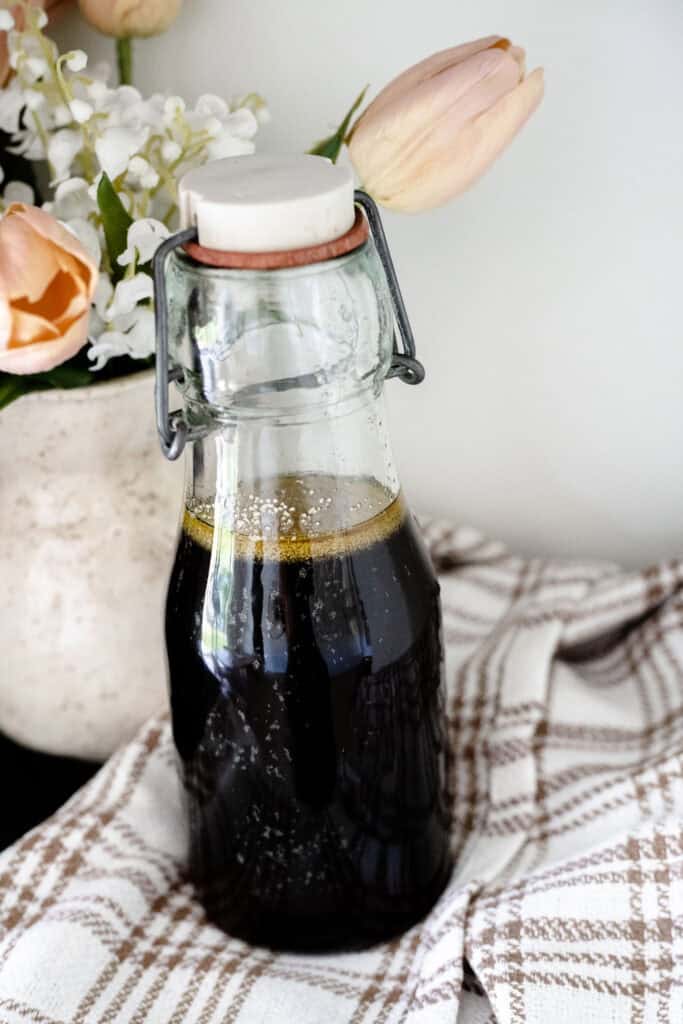bottle of syrup standing in front of pastel flowers