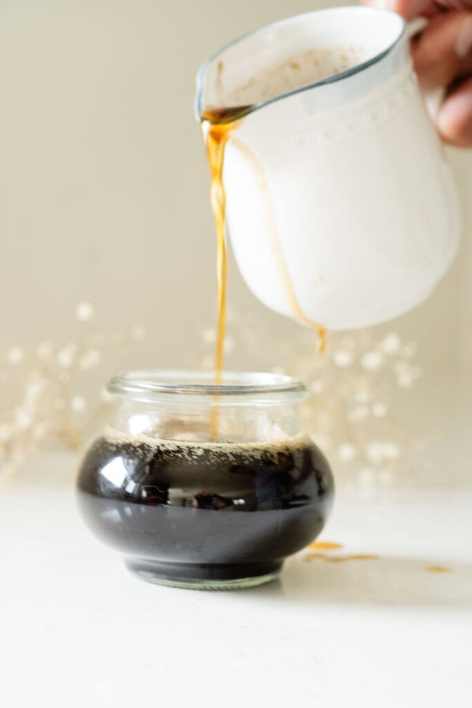brown butter syrup being poured into a jar