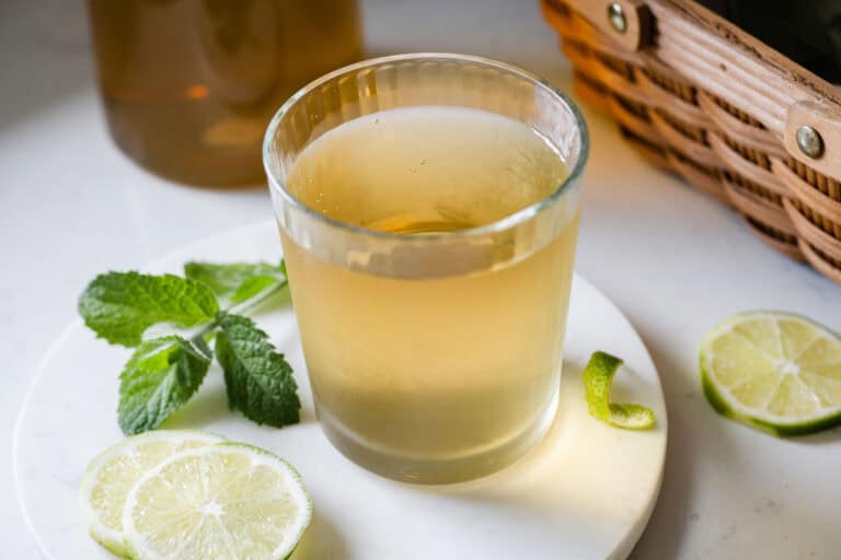 A glass of garden tea with lime slices and mint