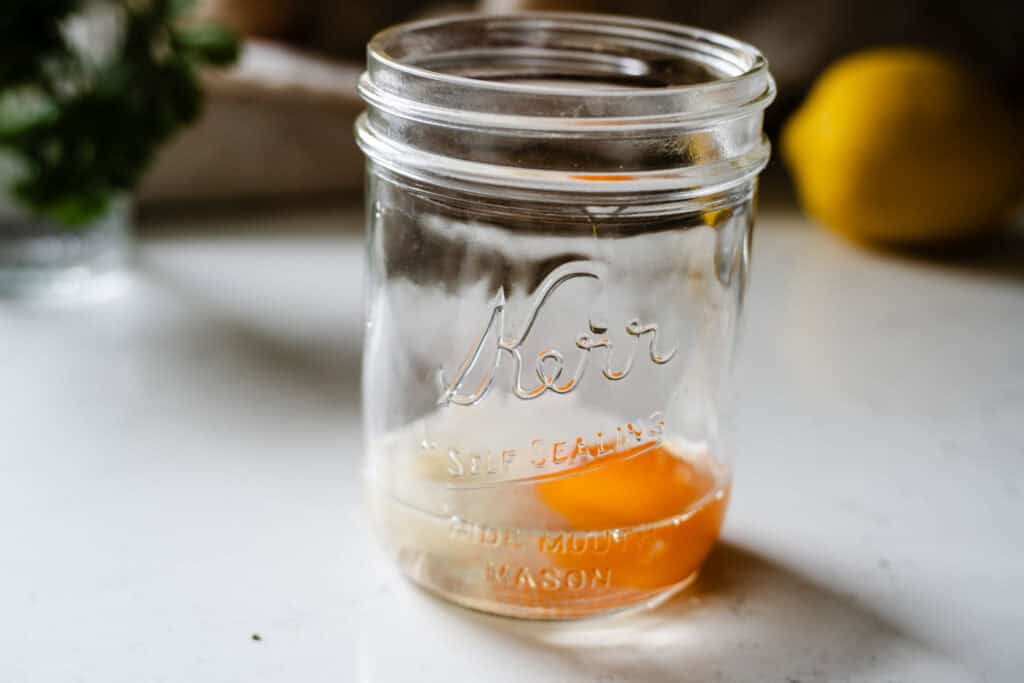 jar with egg, salt, lemon, and dijon mustard