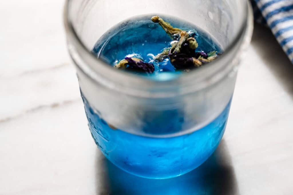 butterfly pea tea flowers steeping in water