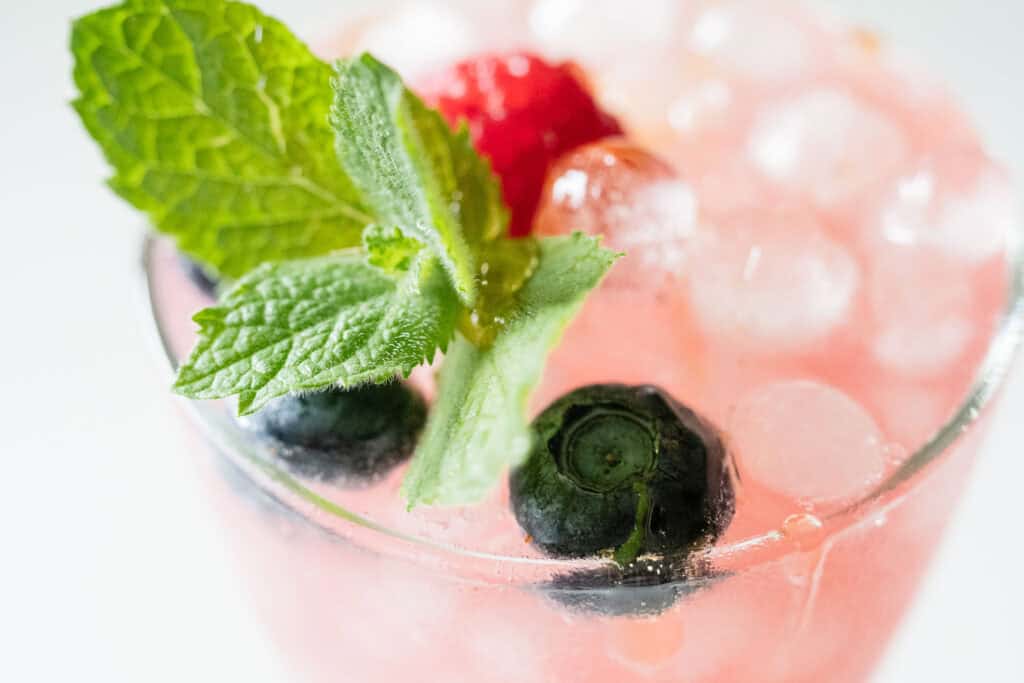 mint and berries topping a fizzy pink drink