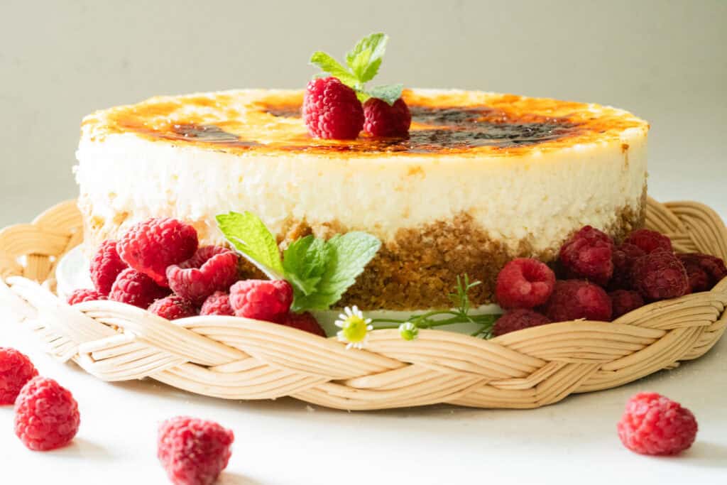 cheesecake topped with a carmalized top and raspberries