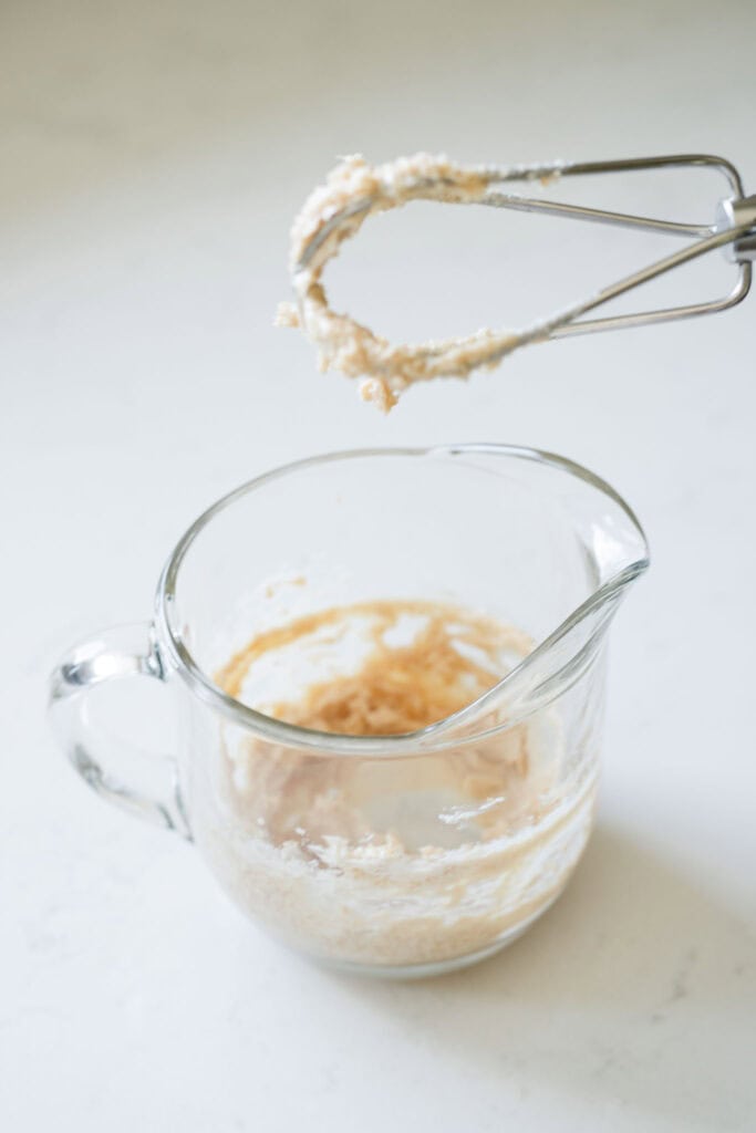 cream cheese and brown sugar being creamed together