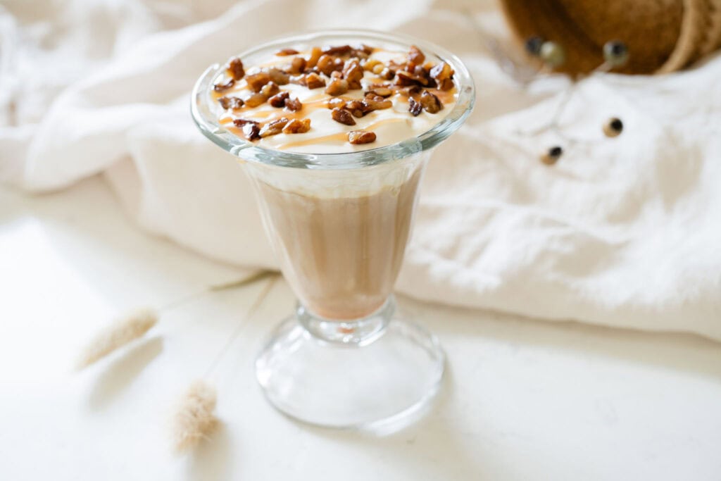 iced latte surrounded by scattered pecans
