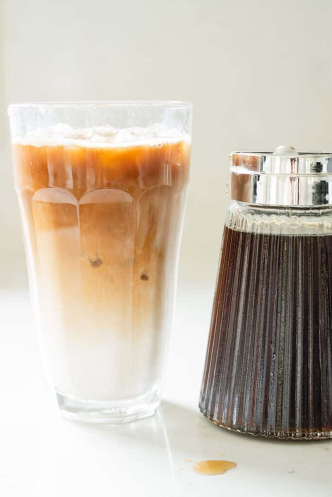 layered iced coffee with a jar of syrup