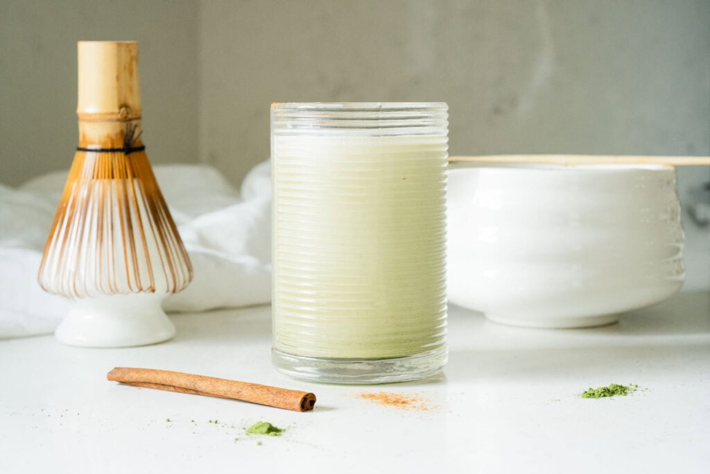 iced green drink with spices scattered around