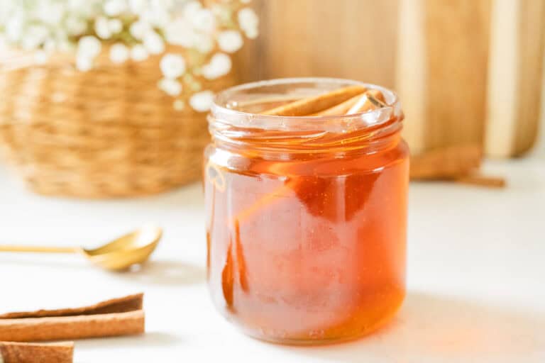 jar of cinnamon honey with flowers in the background