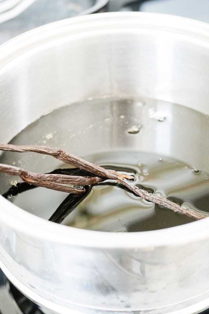 maple syrup and vanilla beans in a saucepan