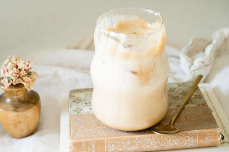 iced latte on a stack of fall colored books