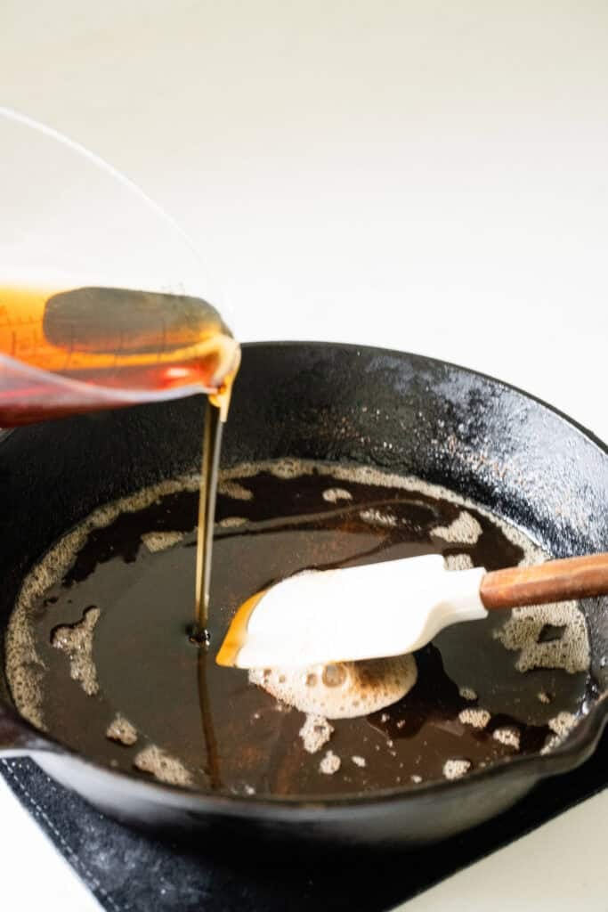 maple syrup being added to browned butter in a pan