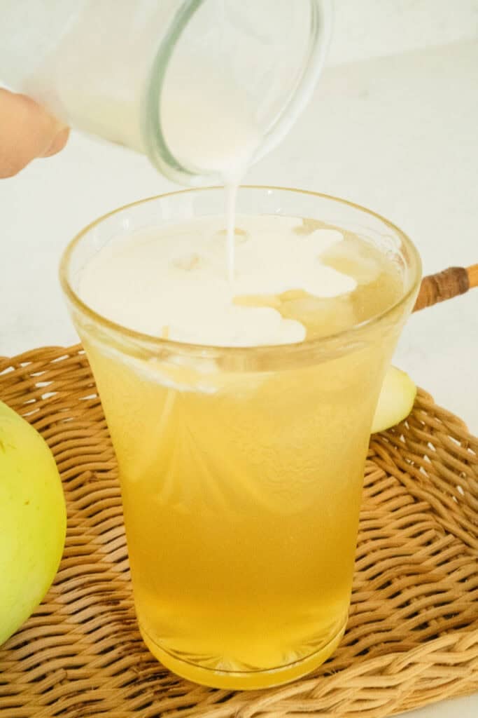 cream drizzling into a cider fizz